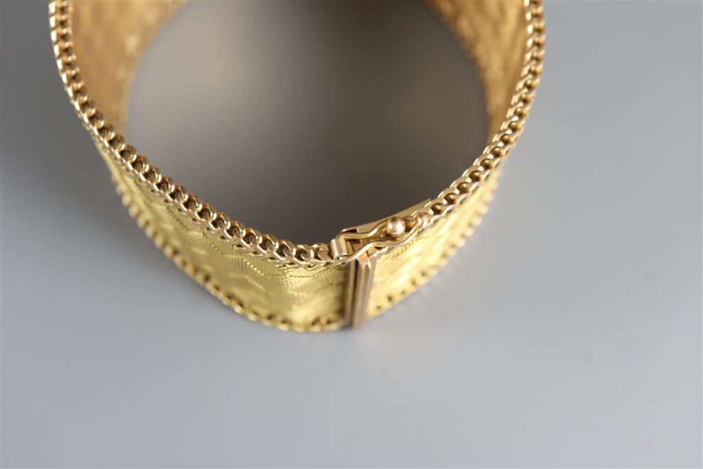 An 18k two colour gold broad mesh link bracelet,